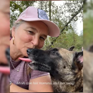 Woman affectionately interacting with her dog outdoors.